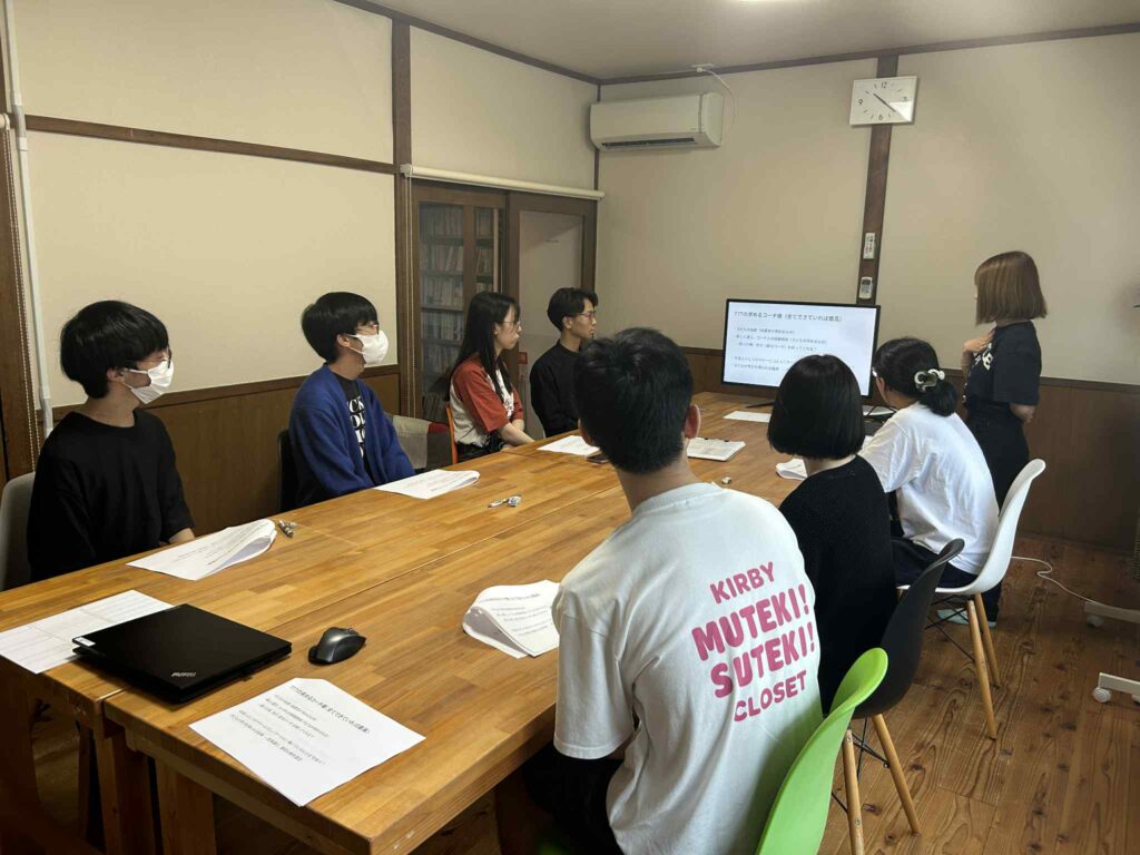 研修でコーチたちが真剣に話を聞いている様子